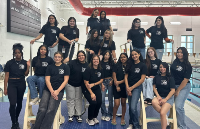 Western Girls Swim Team standing next to Western's pool